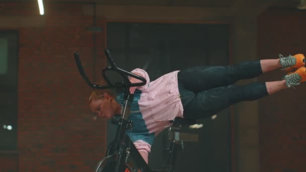 Atletische vrouw maakt twine training routine op het spinnen stationaire fiets in de sportschool, stretching oefeningen — Stockvideo