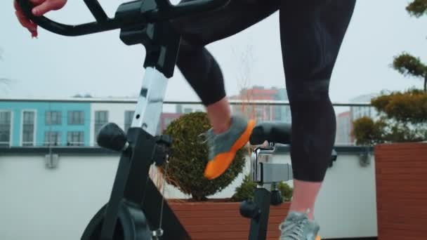 Kadın, simülatörlerde aerobik dayanıklılık antrenmanı, kardiyo çalışması ve bisiklet eğitimi yapıyor. — Stok video
