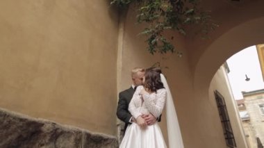 Yeni evliler, beyaz damat, yürüyen, kucaklayan, şehirde kucaklayan, aşık düğün çifti.