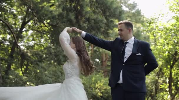 Прекрасные молодожены кавказский жених жених танцует в парке, делает поцелуй, свадебная пара семья — стоковое видео