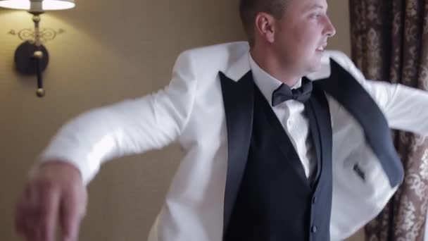 Handsome stylish groom man wearing white jacket at home in living room, slow motion indoors portrait — Vídeo de Stock