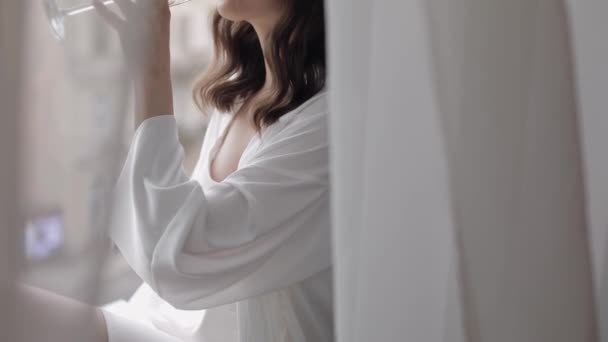 Menyasszony boudoir ruha ül az ablakon párkány esküvő reggeli előkészületek nő hálóingben, fátyol — Stock videók