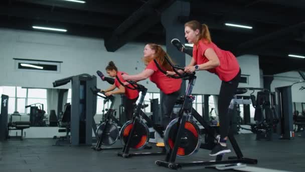 Group of girls performs aerobic training workout cardio routine on bike simulators, cycle training — Stock Video