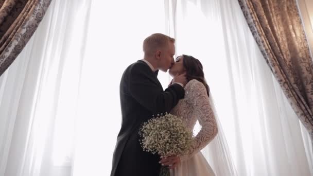 Newlyweds portrait, caucasian groom bride walking, embracing, hugs in large room, wedding couple — Stockvideo