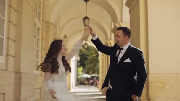 Newlyweds portrait, caucasian groom bride dancing, embracing, hugs on city street, wedding couple — Stok video