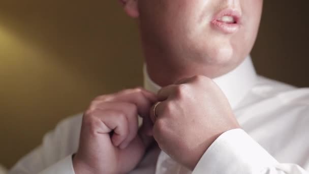 Κομψό άνθρωπος στο σακάκι στερεώνει τα κουμπιά, κουμπιά λευκό πουκάμισο ετοιμάζεται να βγει κοντά στο παράθυρο — Αρχείο Βίντεο