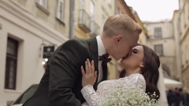 Friss házasok, fehér vőlegény menyasszony séta, ölelés, ölelés a városban, esküvő pár szerelmes — Stock videók