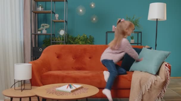 Kleines Grundschulmädchen sitzt allein zu Hause auf dem Sofa — Stockvideo