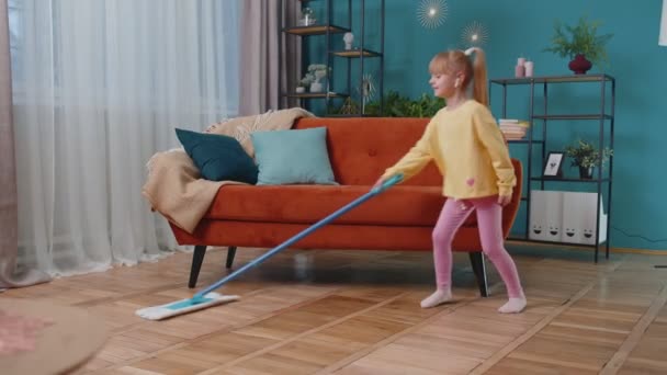 Engraçado criança menina garoto limpeza lava pisos com uma esfregona em casa dançando, cantando em humor positivo — Vídeo de Stock