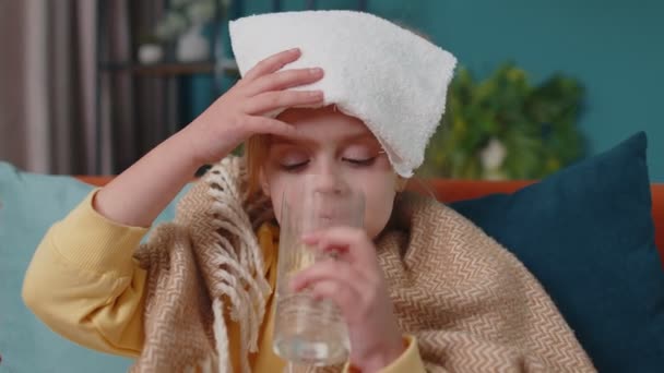 Девочка в клетчатой клетке страдает от холода или аллергии, пьет таблетки таблетки воды в домашних комнатах — стоковое видео