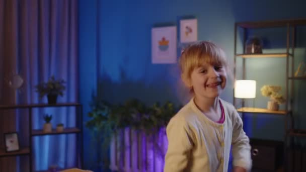 Πορτρέτο χαρούμενος μικρό παιδί κορίτσι χορεύει μοντέρνο χορό, ενώ ακούγοντας μουσική στο σπίτι το βράδυ και μόνο — Αρχείο Βίντεο