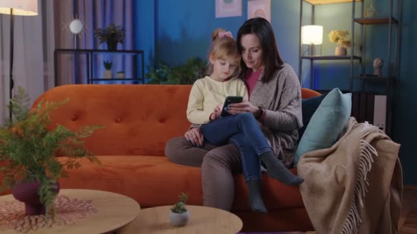 Mère et fille enfant fille regardant smartphone réjouissant gagner, recevoir un message avec de bonnes nouvelles — Video