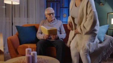 Büyük anne ve büyük baba çift rahatlıyor, kitap okuyor, gece evde hobilerinin keyfini çıkarıyorlar.