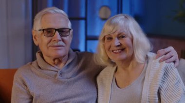 Mutlu, yaşlı, yaşlı bir çift. Kucaklaşıyor, gülüyor, kameraya bakıyor.