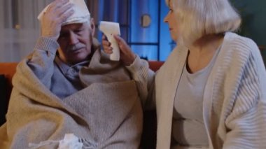 Üst düzey çiftler Coronavirus kilitlemesi sırasında temassız dijital termometreyle sıcaklık ölçer.