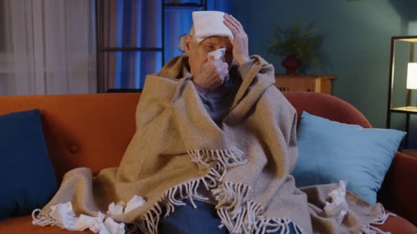 Hombre abuelo mayor que sufre de frío o alergia, sopla mocos en la nariz servilleta sentada en casa — Vídeos de Stock