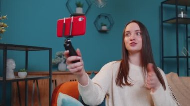 Blog yazarı etkileyicisi akıllı telefondan selfie çekiyor, evde sanal sosyal medya videosu çekiyor