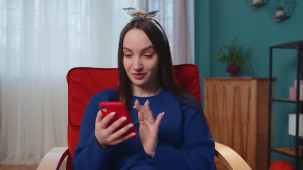 Wanita dewasa muda di rumah menggunakan ponsel mengetik browsing mengatakan wow ya menemukan kemenangan besar — Stok Video