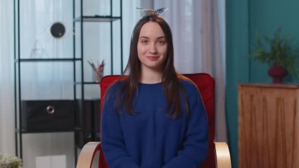 Porträtt av lycklig en vacker tonåring student flicka ler, tittar på kameran hemma på stol — Stockvideo