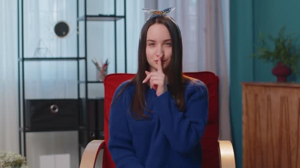 Молода жінка натискає вказівний палець на губи робить знак жесту тиші не розповідає секрет вдома — стокове відео