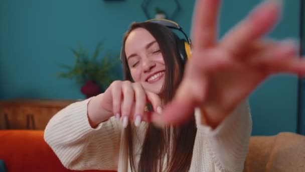 Jolie jeune femme caucasienne dans les écouteurs écouter de la musique danser, chanter dans le salon à la maison — Video