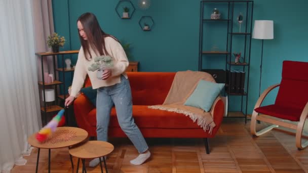 Gelukkige jonge vrouw stofferen meubels verzorging voor hygiëne met behulp van kleurrijke stofdoek in de woonkamer thuis — Stockvideo