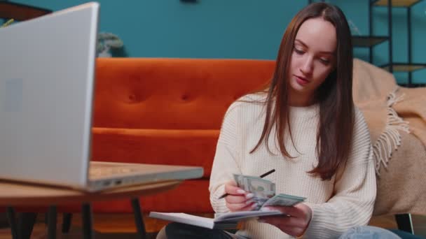 Vrouw aan het doen, huisbudget plannen op laptop en geld tellen, meisje dat dollar contant inkomen controleert — Stockvideo