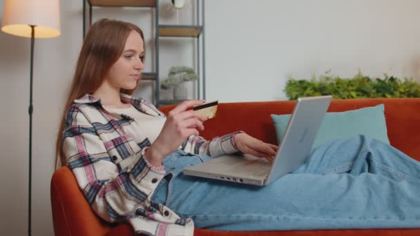 Mulher sentada em casa usando cartão de crédito bancário e laptop pc durante a transferência de dinheiro compras on-line — Vídeo de Stock
