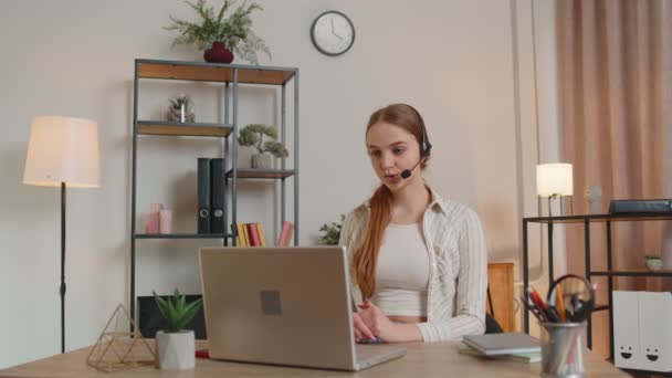 Mulher com fone de ouvido usando laptop, falando, operador de serviço de suporte ao cliente trabalhando no escritório em casa — Vídeo de Stock
