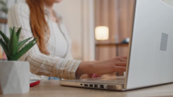 Jonge vrouw meisje met behulp van laptop computer zitten aan tafel werken, typen op het toetsenbord van thuis kantoor — Stockvideo