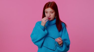 Yorgun, kızıl saçlı bir kadın gözlüğünü çıkarıyor, gözleri acıyor, işten yorgun düşüyor.