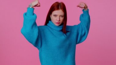 Kız pazılarını gösteriyor, haklar için savaşma gücü hissediyor, başarı için enerji kazanıyor.