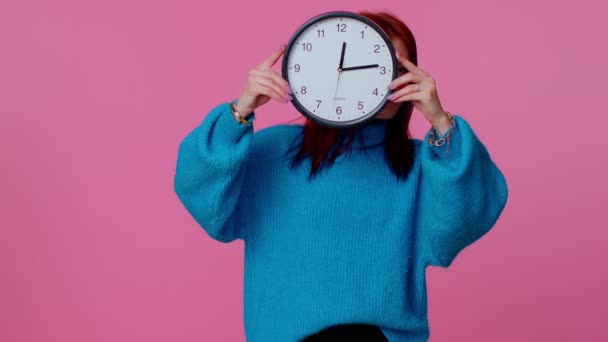 Young woman holding clock watch, hiding, checking time on clock, running late to work being in delay — Stock Video