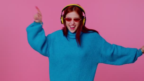 Cheerful attractive girl listening music via headphones and dancing disco fooling around having fun — Stock Video