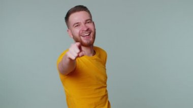 Adam kamerayı işaret ediyor, yüksek sesle gülüyor, komik görünüşle dalga geçiyor, komik bir şaka.