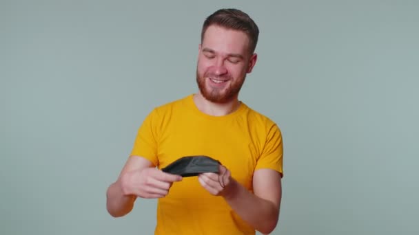 Jeune homme souriant enlevant joyeusement le masque médical et le jetant célébrant la fin du coronavirus — Video