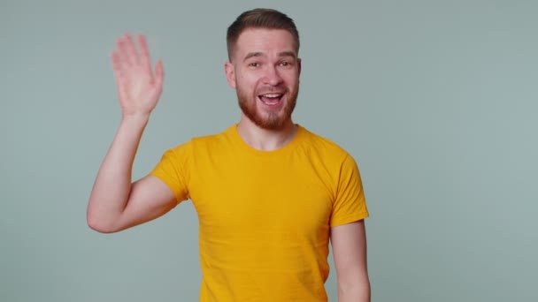 Homme barbu souriant amical à la caméra et agitant les mains geste bonjour ou au revoir, accueillant — Video