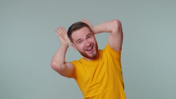 Adorável engraçado homem sorrindo amigável, fazendo orelhas de coelho gesto na cabeça se divertindo enganando humor cômico — Vídeo de Stock