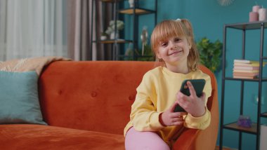 Kız çocuk cep telefonuyla konuşmaktan zevk alıyor. Arkadaşlarıyla evde tek başına oturuyor.