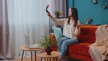 Blog yazarı etkileyicisi akıllı telefondan selfie çekiyor, evde sanal sosyal medya videosu çekiyor