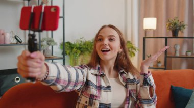 Blog yazarı etkileyicisi akıllı telefondan selfie çekiyor, evde sanal sosyal medya videosu çekiyor