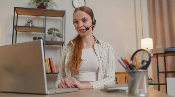 Mujer freelance usar auriculares hacer video llamada enseñanza tutoría hablar en el ordenador portátil en la oficina en casa —  Fotos de Stock