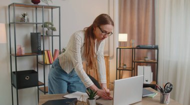 İç işlerinde masa başında duran genç bir kadın kağıt dökümanlarında çalışıyor, verileri analiz ediyor.