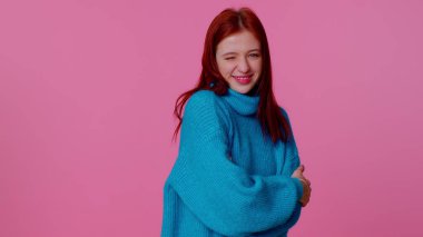 Gülümseyen kızıl mutlu kız göz kırpıyor, dişlek gülümsemeyle kameraya bakıyor, göz kırpıyor ve flört ediyor.