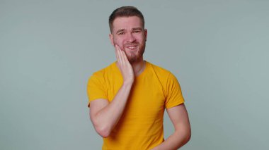 Diş ağrısı ya da diş eti iltihabından muzdarip bir adam dişçi randevusunu bekliyor.