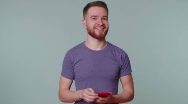 Mutlu, heyecanlı adam cep telefonu kullanıyor. 