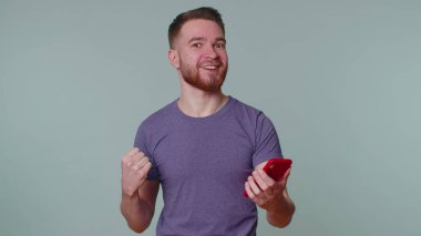 Mutlu, heyecanlı adam cep telefonu kullanıyor. 