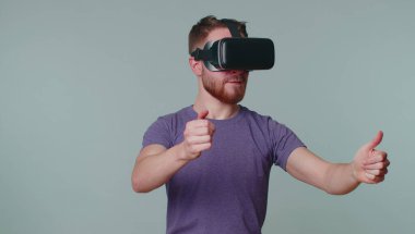 Sanal gerçeklik teknolojisi kullanan adam 3D video oyunu canlandırmak için VR kulaklık kullanıyor.