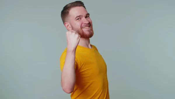 Snygg man i t-shirt skriker, höjer knytnävarna i gest Jag gjorde det, firar framgång, vinna — Stockfoto