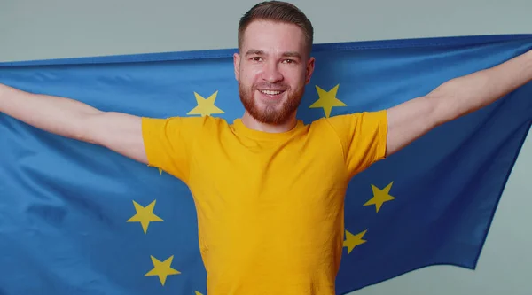El hombre ondeando la bandera de la Unión Europea, sonriendo, aplaudiendo las leyes democráticas, los derechos humanos, las libertades en Europa — Foto de Stock